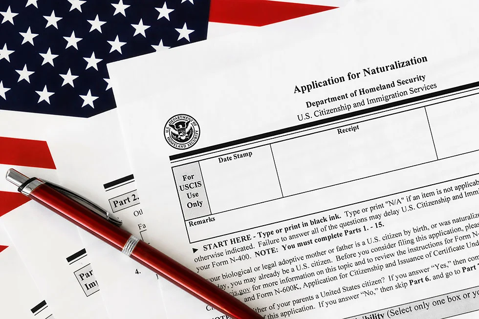 close-up of n-400 form. application for naturalization topview, on a background of United States flag.